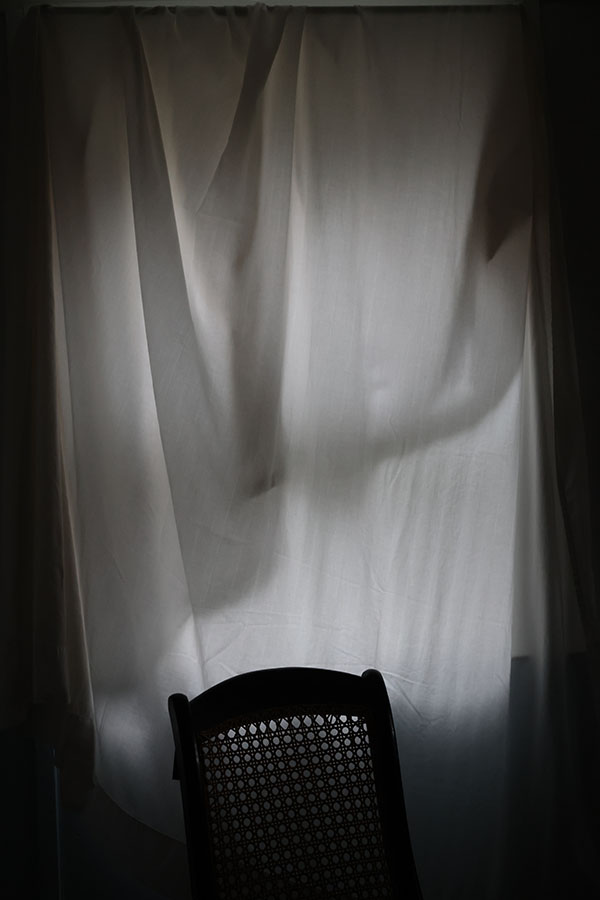 Graphic Color Photo of Sheet Draped Window with Chair.